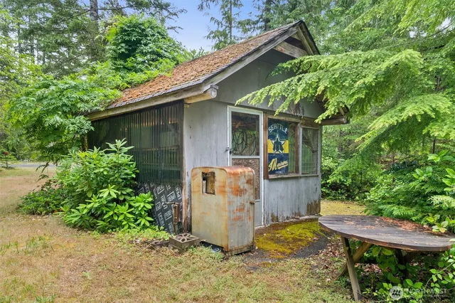 a view of a house with a yard and large tree