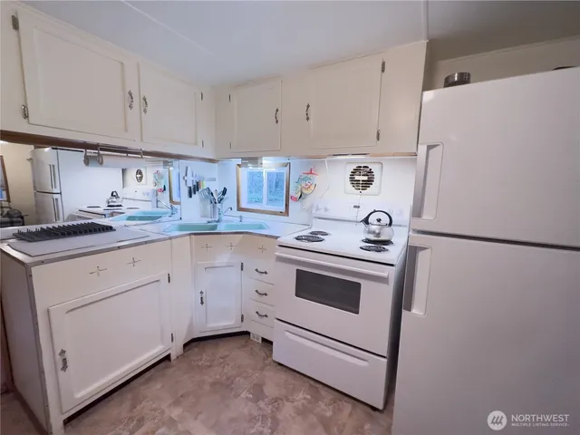 a kitchen with cabinets appliances a sink and a counter top