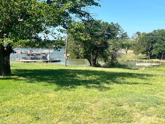 8983 County Road 299 Graham, TX 76450 - Photo 5 of 7 View of grassy yard featuring a water view and a dock