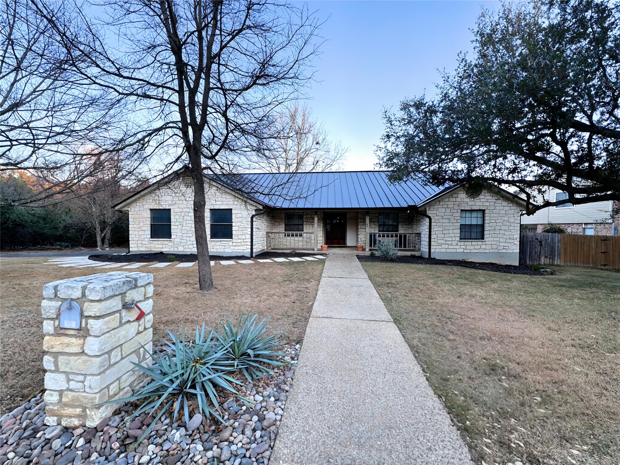 a front view of house with yard and trees in the background