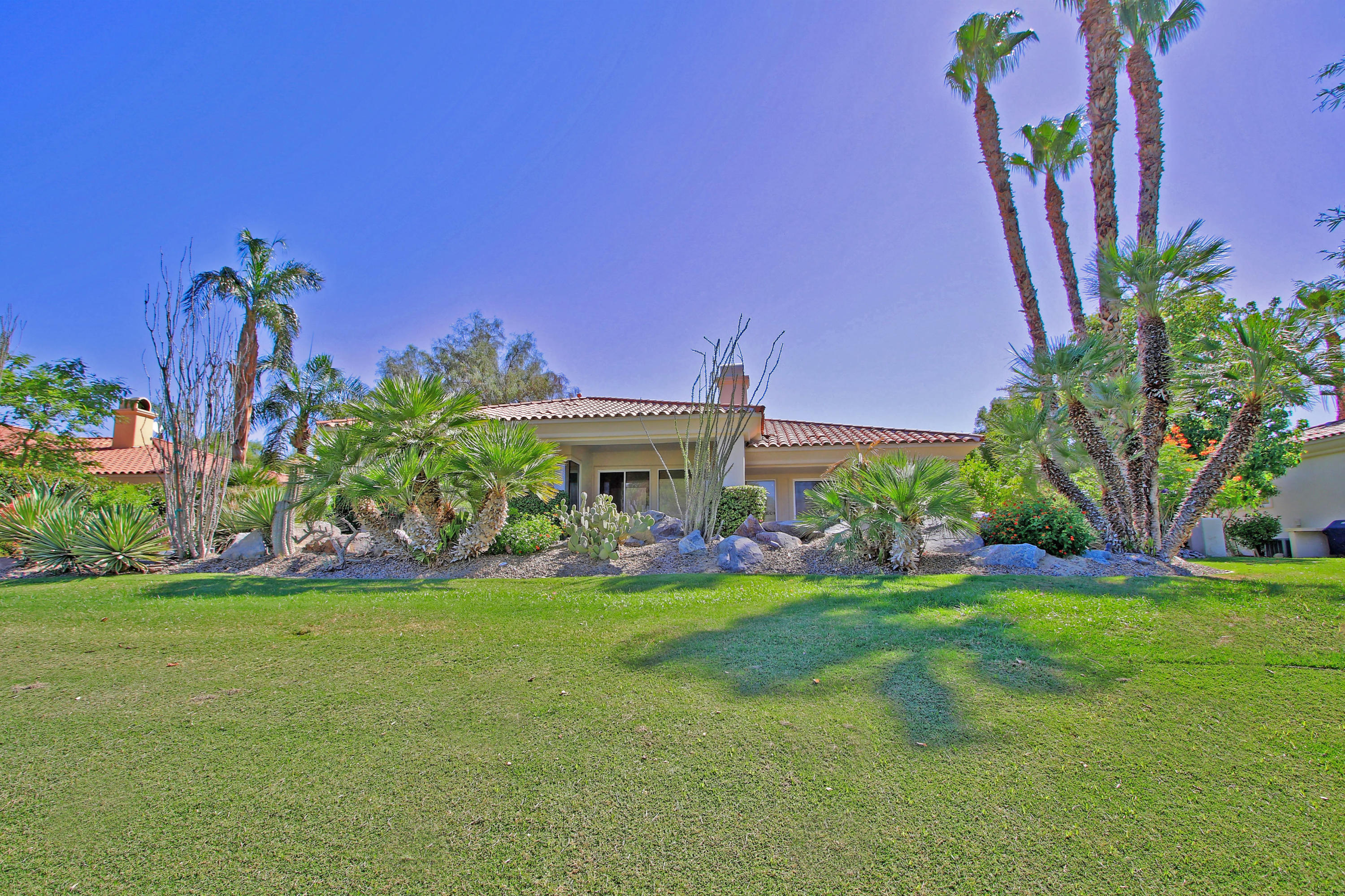 198 Loch Lomond Road Rancho Mirage, CA 92270 - Photo 3 of 5 a view of a house with a yard and potted plants