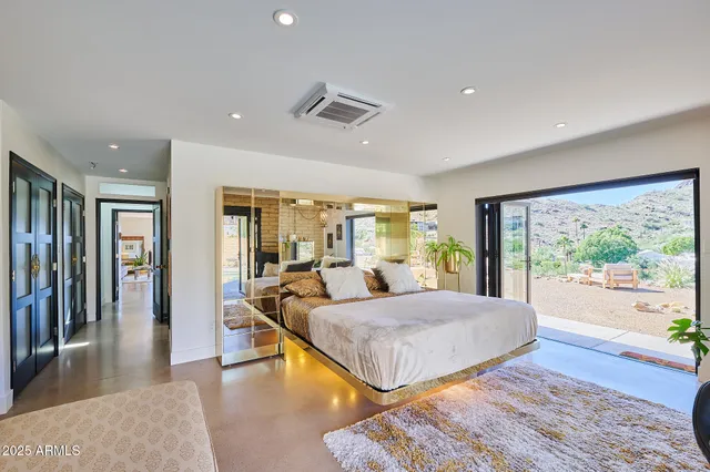 a spacious bedroom with a bed and glass windows
