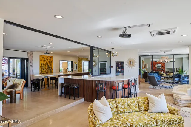a living room with lots of furniture and kitchen view