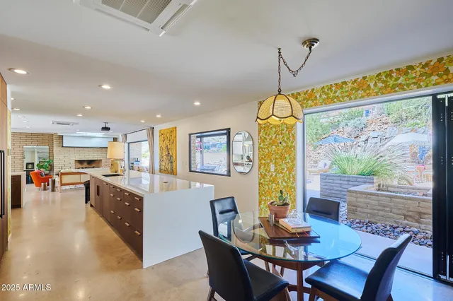a dining room with furniture a floor to ceiling window and wooden floor
