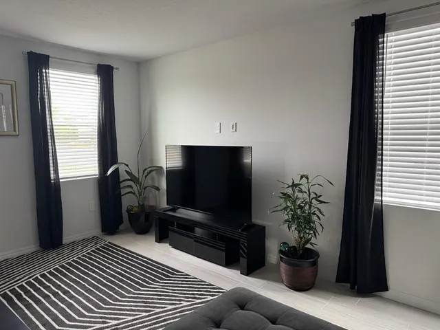 a living room with furniture and a potted plant