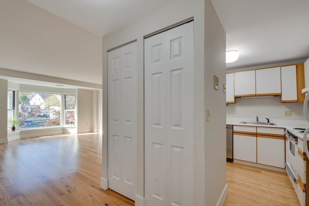 1 Watermill Place, Unit 308 Arlington, MA 02476 - Photo 13 of 27 an empty room with wooden floor cabinet and windows