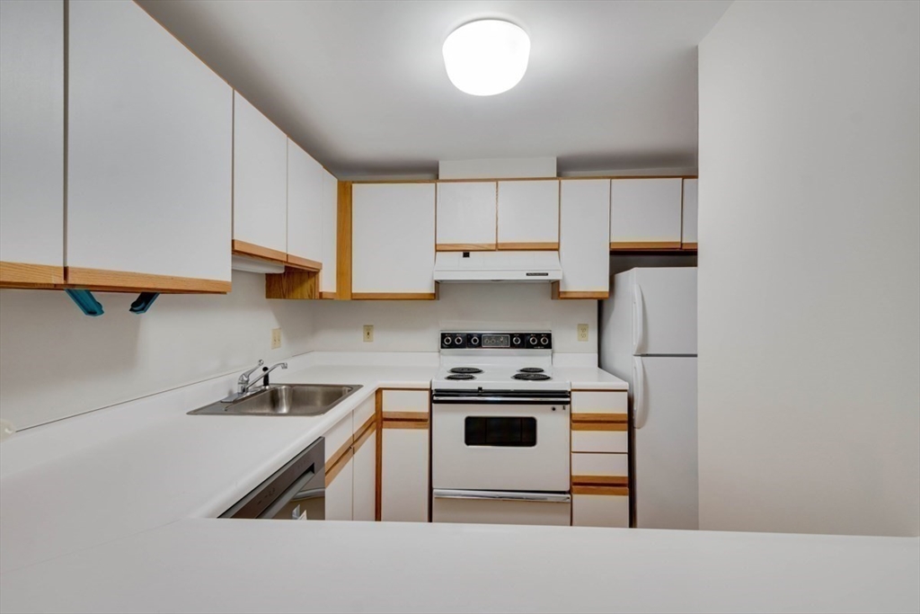 1 Watermill Place, Unit 308 Arlington, MA 02476 - Photo 16 of 27 a kitchen with a stove a sink and a refrigerator