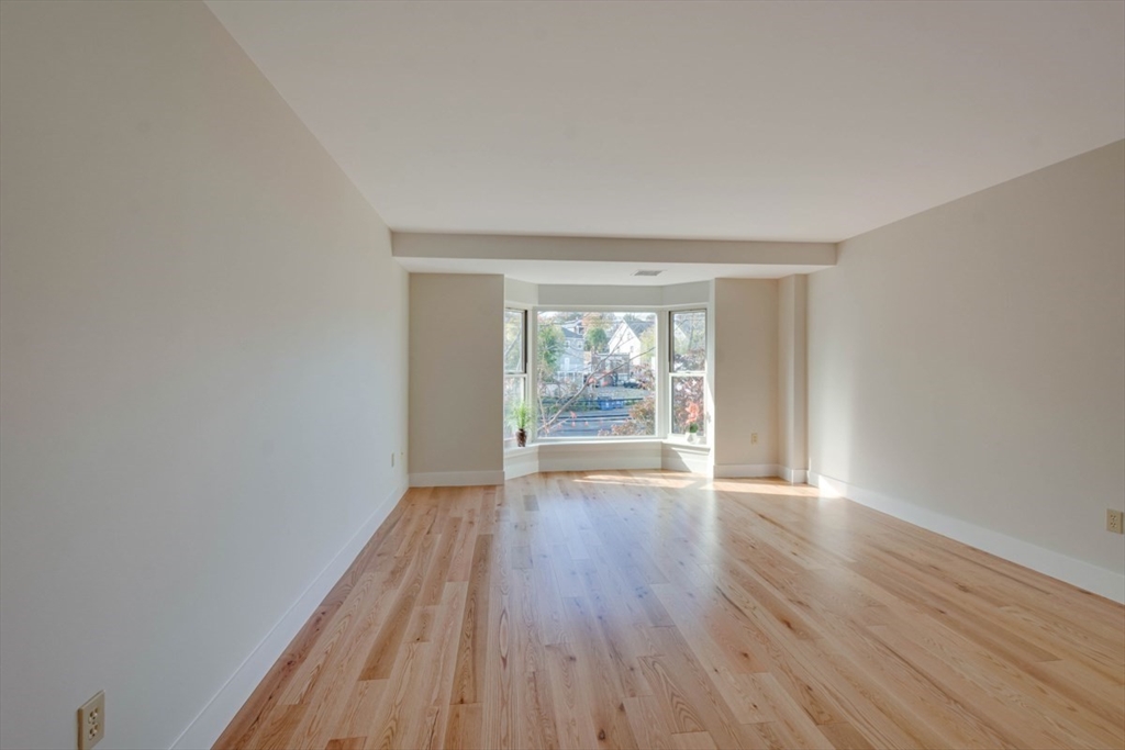 1 Watermill Place, Unit 308 Arlington, MA 02476 - Photo 3 of 27 wooden floor in an empty room with a window
