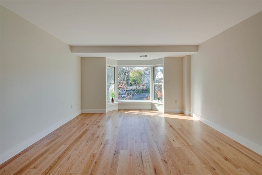 1 Watermill Place, Unit 308 Arlington, MA 02476 - Photo 4 of 27 wooden floor in an empty room with a window