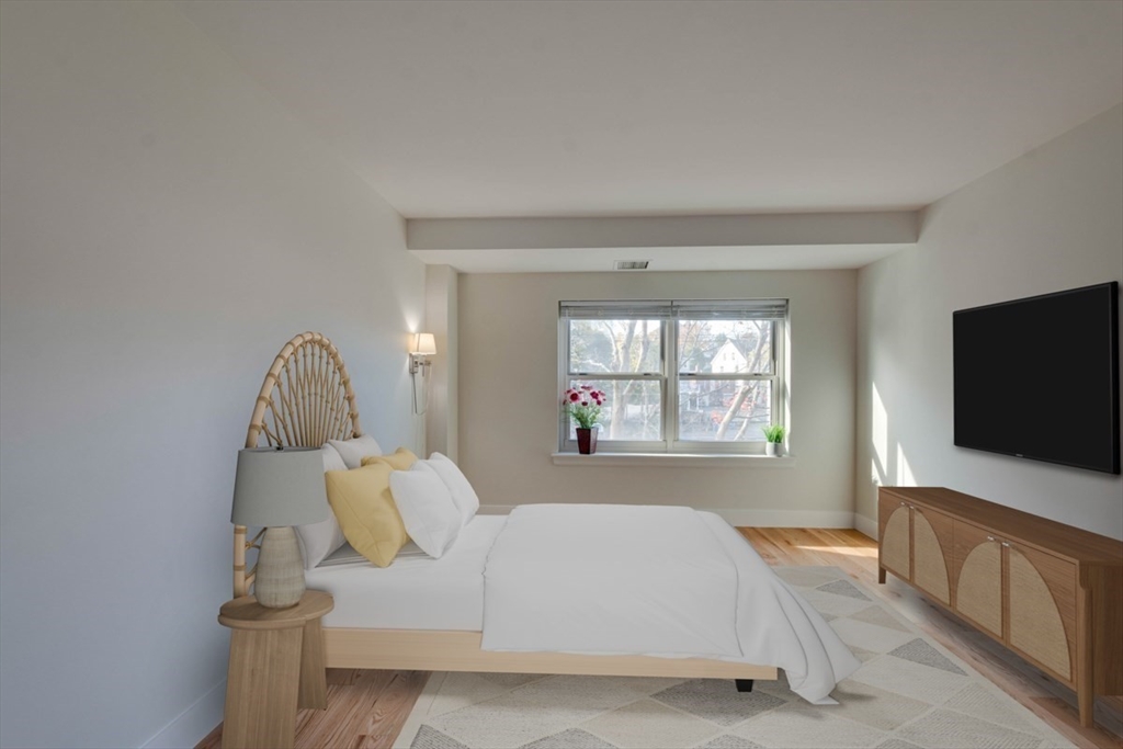 1 Watermill Place, Unit 308 Arlington, MA 02476 - Photo 7 of 27 a spacious bedroom with a bed and a flat tv screen on the dresser
