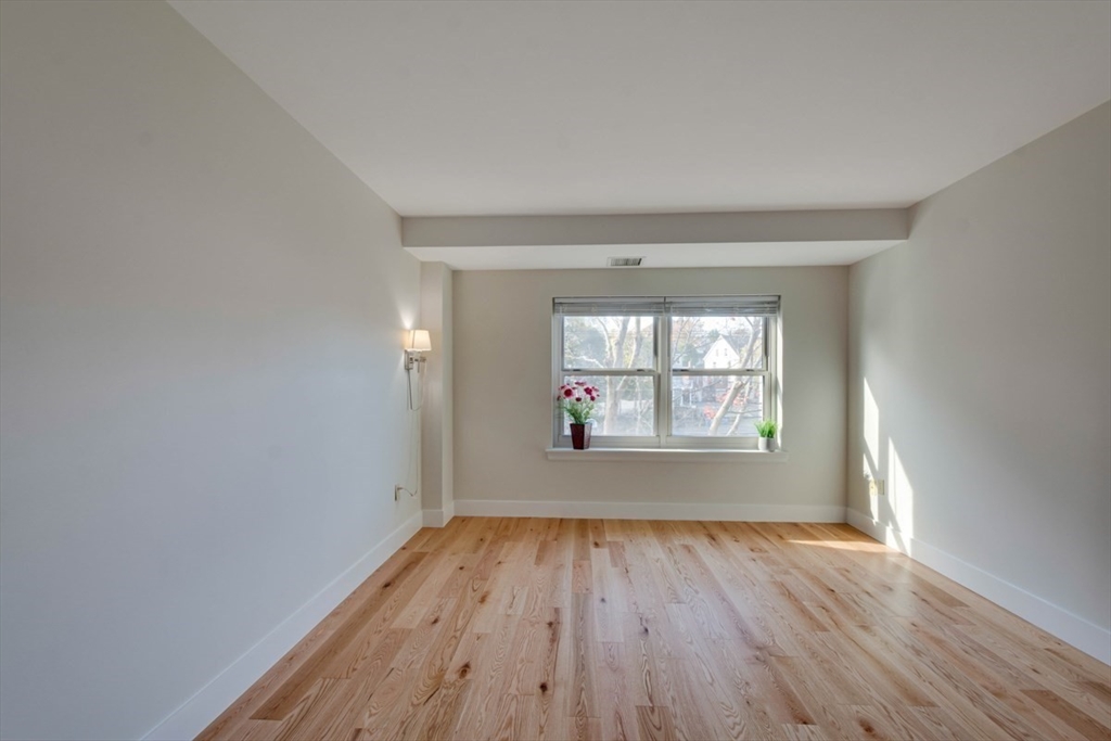 1 Watermill Place, Unit 308 Arlington, MA 02476 - Photo 9 of 27 an empty room with wooden floor and windows