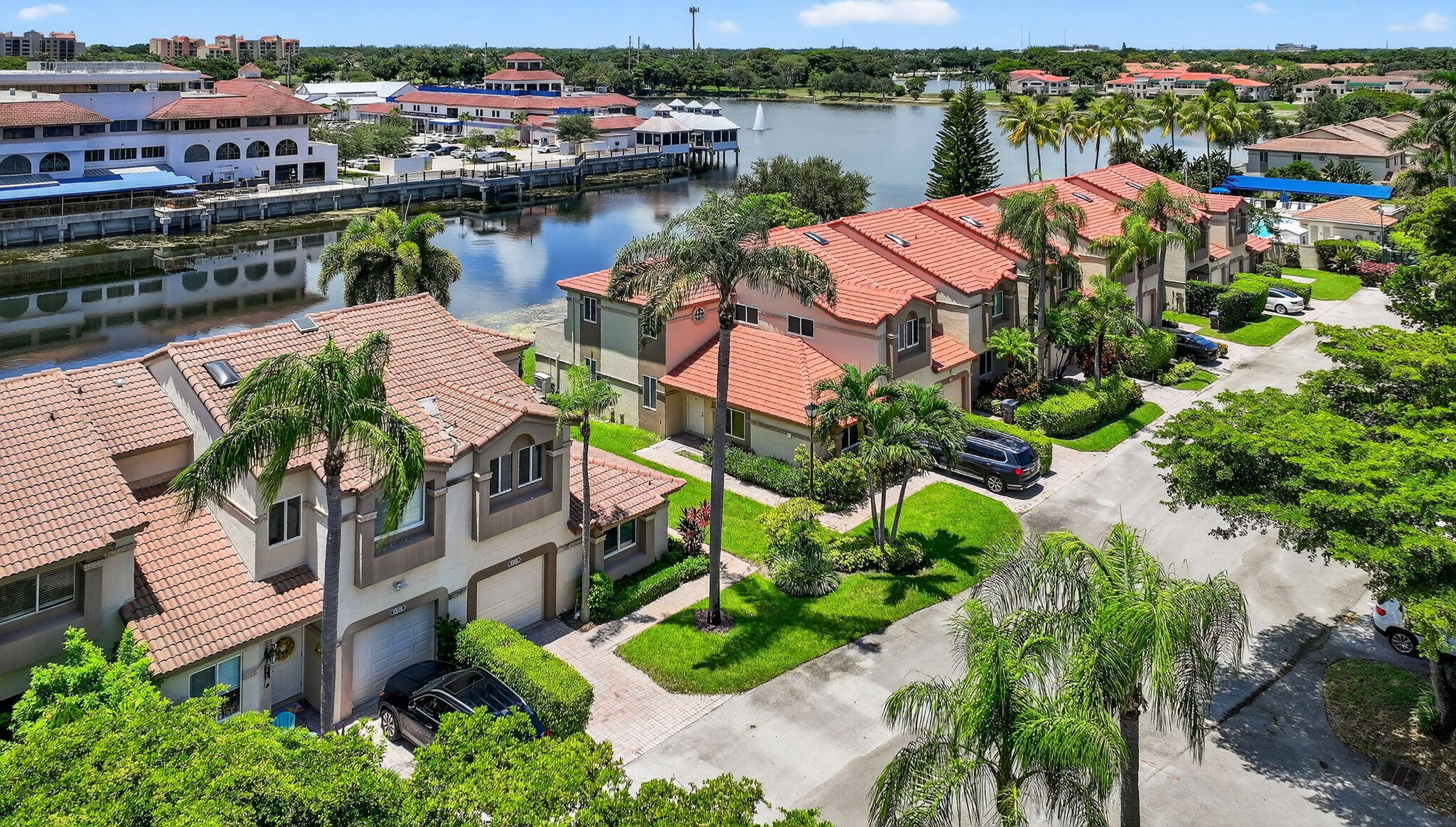 an aerial view of a residential houses with outdoor space and lake view