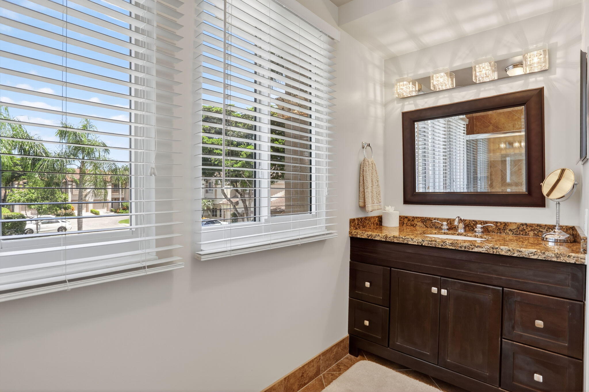 6806 Via Regina Boca Raton, FL 33433 - Photo 39 of 51 a bathroom with a granite countertop sink and a large mirror next to a window