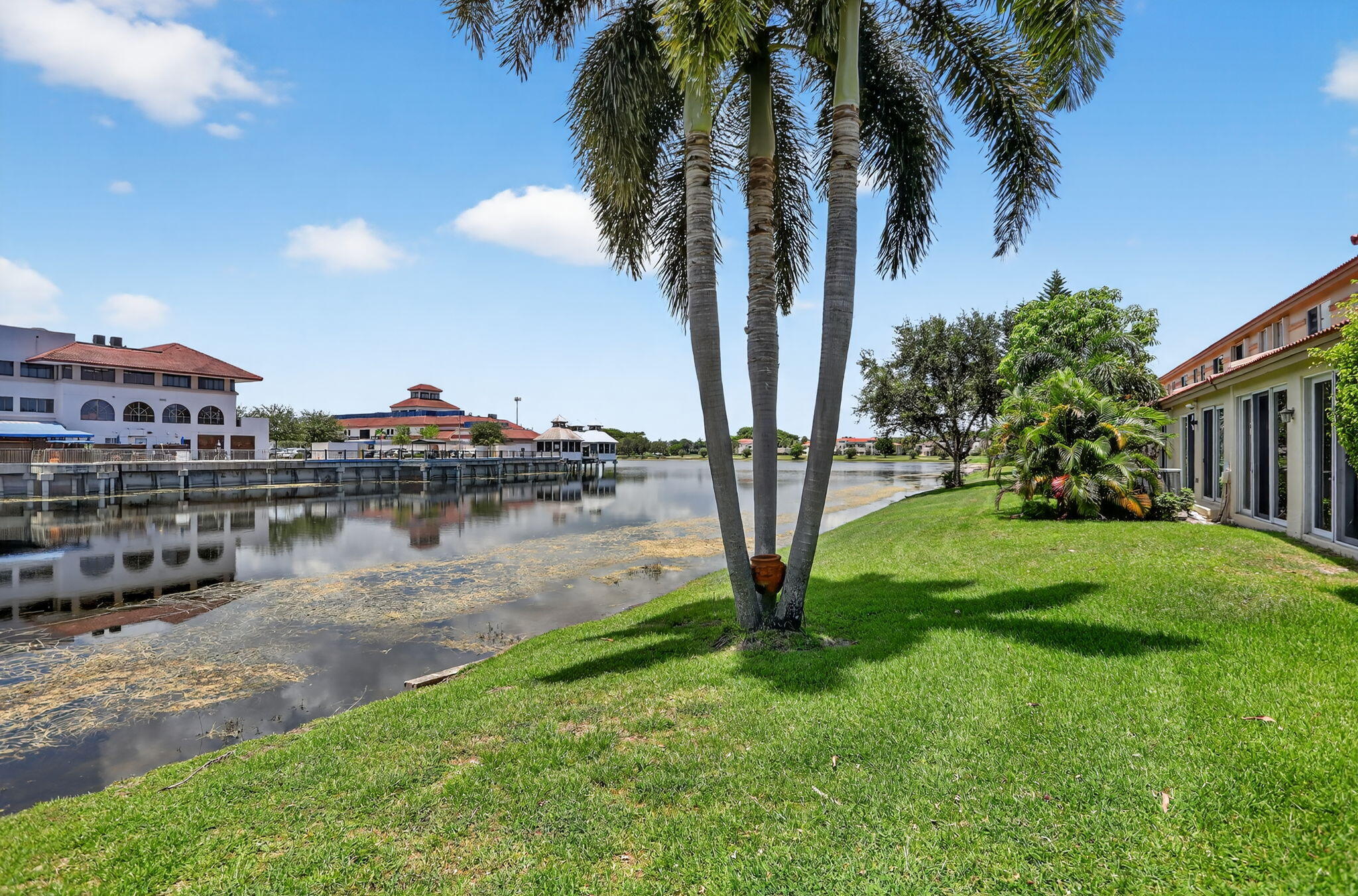 6806 Via Regina Boca Raton, FL 33433 - Photo 48 of 51 a view of a lake with a yard and palm trees