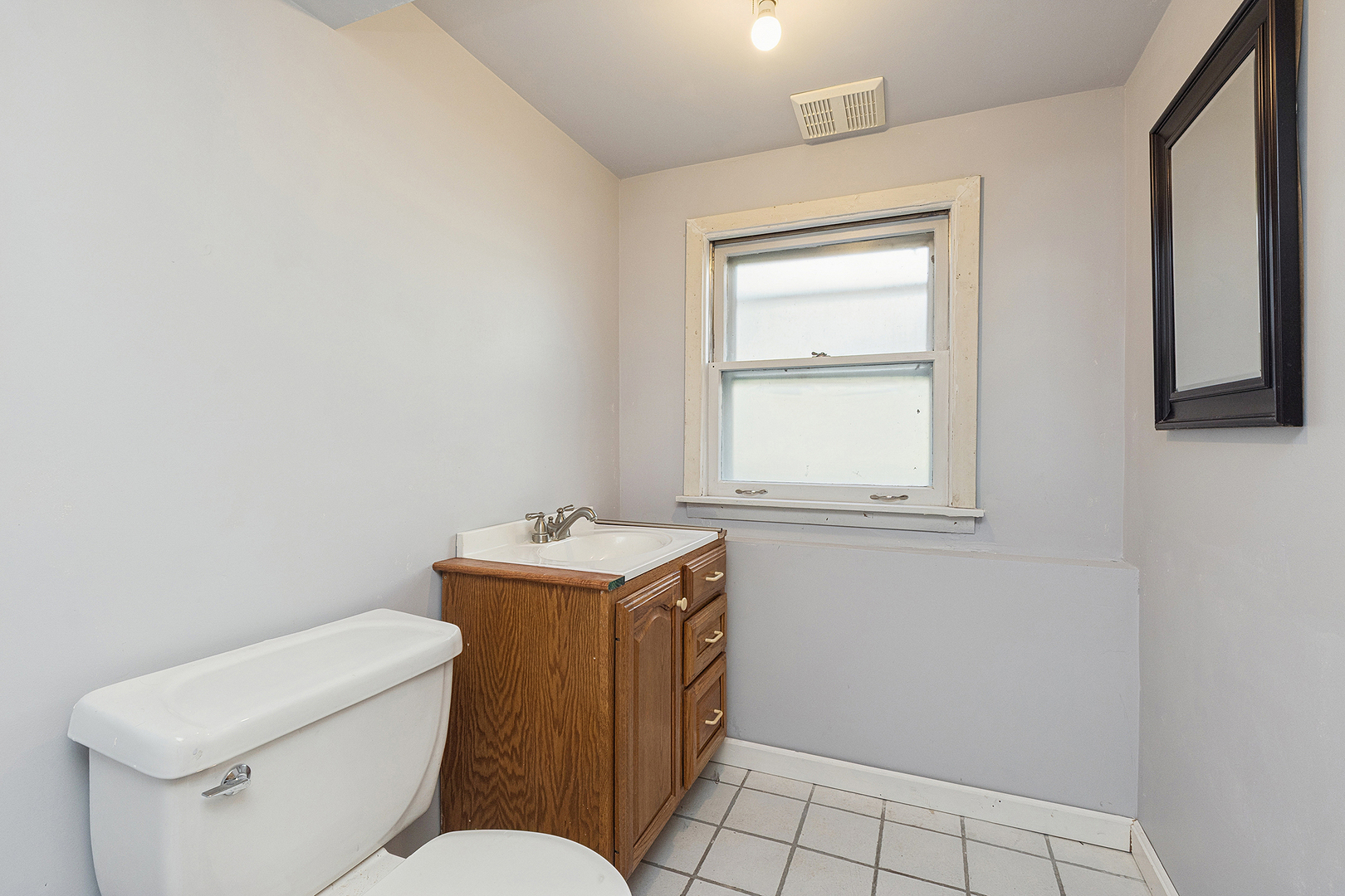 558 Birchwood Road Frankfort, IL 60423 - Photo 12 of 16 a bathroom with a toilet a sink a vanity and window
