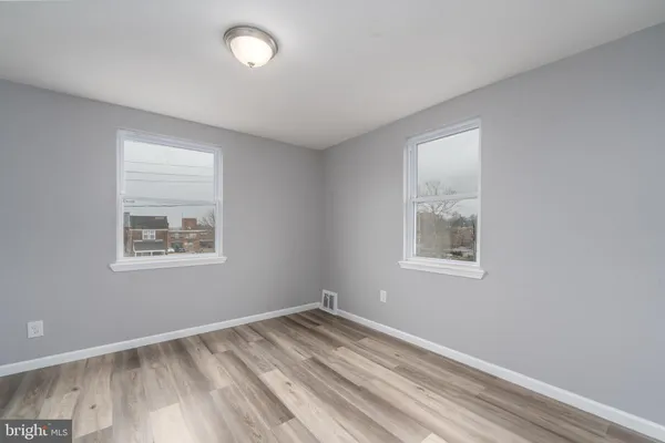 a view of empty room with wooden floor