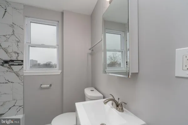 a bathroom with a sink mirror and toilet