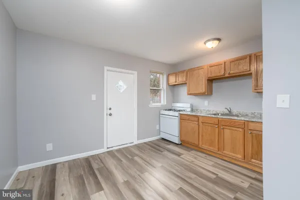 a kitchen with granite countertop a sink cabinets and wooden floor