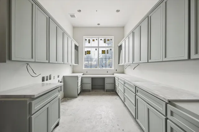 a kitchen with white cabinets and sink