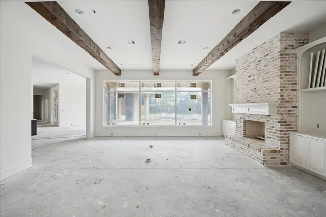 a view of an empty room with a fireplace and a window