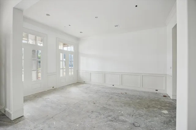 a view of an empty room with chandelier and window