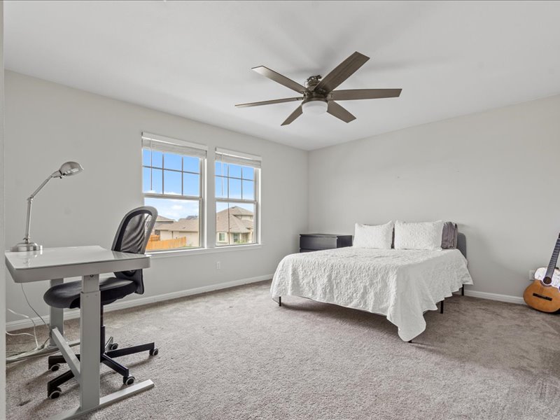 8201 Daisy Cutter Crossing Georgetown, TX 78626 - Photo 12 of 31 Bedroom with carpet floors, a desk, and ceiling fan