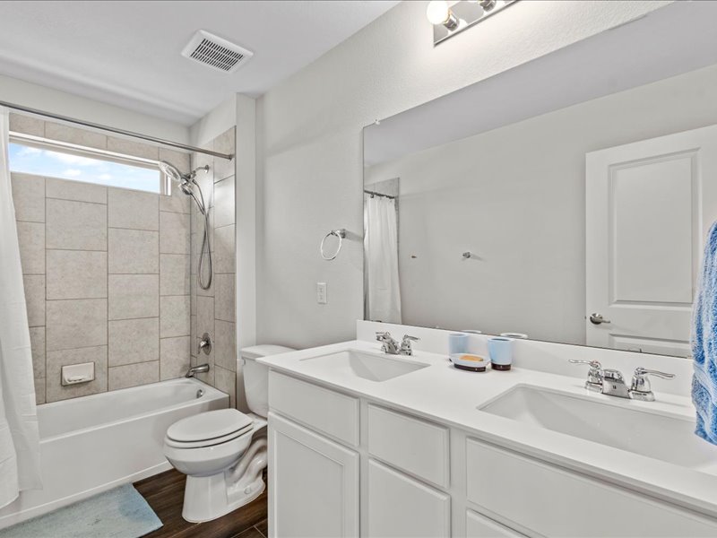 8201 Daisy Cutter Crossing Georgetown, TX 78626 - Photo 17 of 31 Bathroom featuring shower / bath combo, double vanity, and dark wood-style flooring