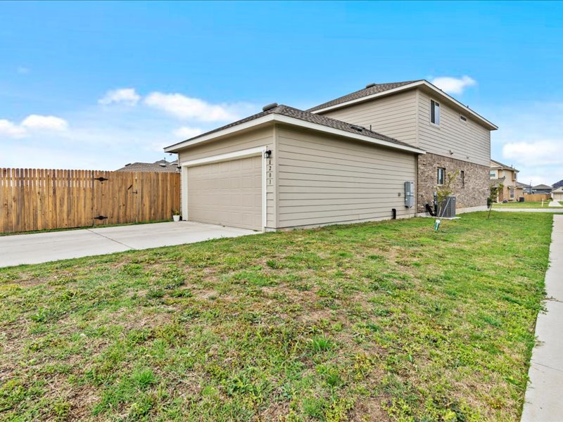 8201 Daisy Cutter Crossing Georgetown, TX 78626 - Photo 21 of 31 View of home's exterior with concrete driveway, an attached garage, a gate, and brick siding