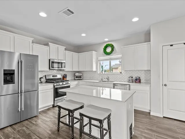 a kitchen with a stove a sink and a refrigerator
