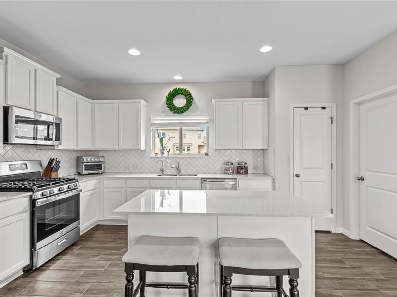 8201 Daisy Cutter Crossing Georgetown, TX 78626 - Photo 9 of 31 Kitchen with stainless steel appliances, white cabinets, a kitchen breakfast bar, and recessed lighting