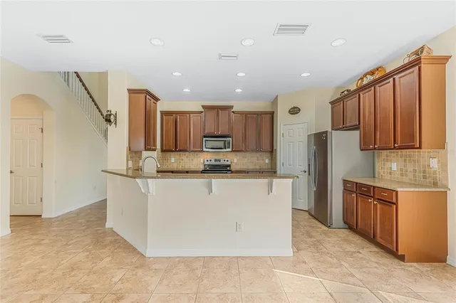 a kitchen with stainless steel appliances granite countertop a sink stove and microwave