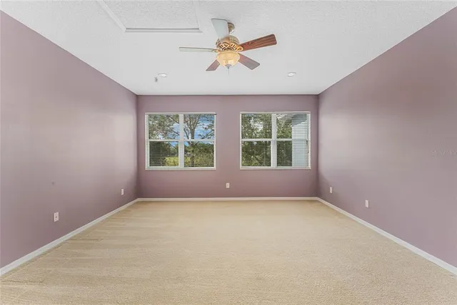 en empty room with a ceiling fan and a rug