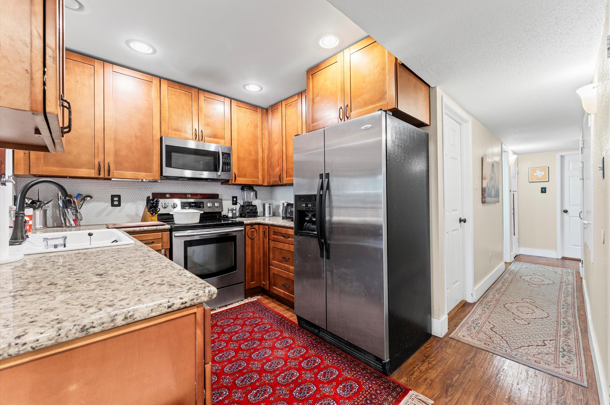 1504 Early Lane Houston, TX 77055 - Photo 3 of 23 a kitchen with stainless steel appliances granite countertop a refrigerator a stove a sink and a microwave