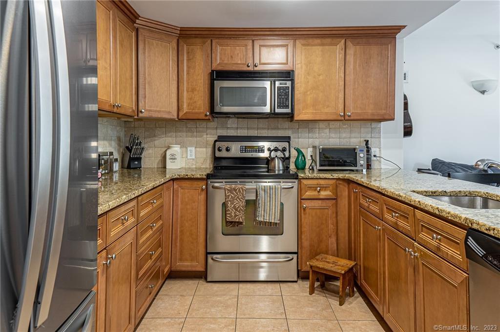 a kitchen with stainless steel appliances granite countertop a stove microwave and cabinets