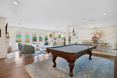 a room with furniture pool table and wooden floor