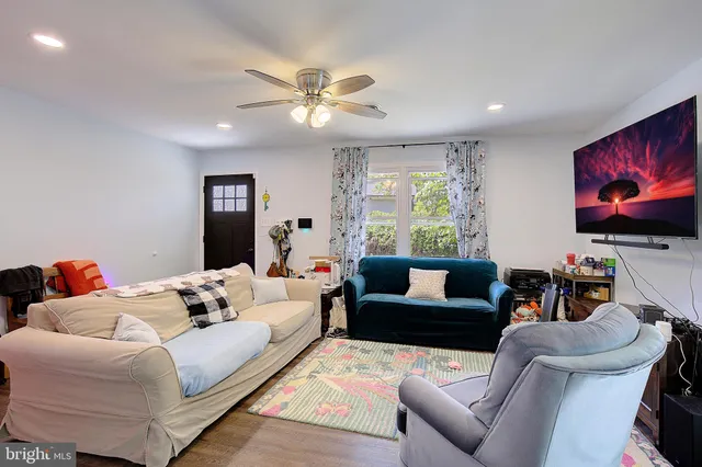 a living room with furniture and a wooden floor