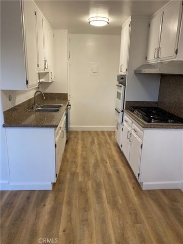 a kitchen with granite countertop a sink stove and cabinets