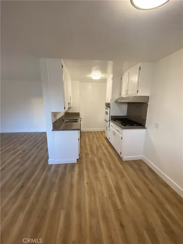 a kitchen with granite countertop a sink and a stove top oven
