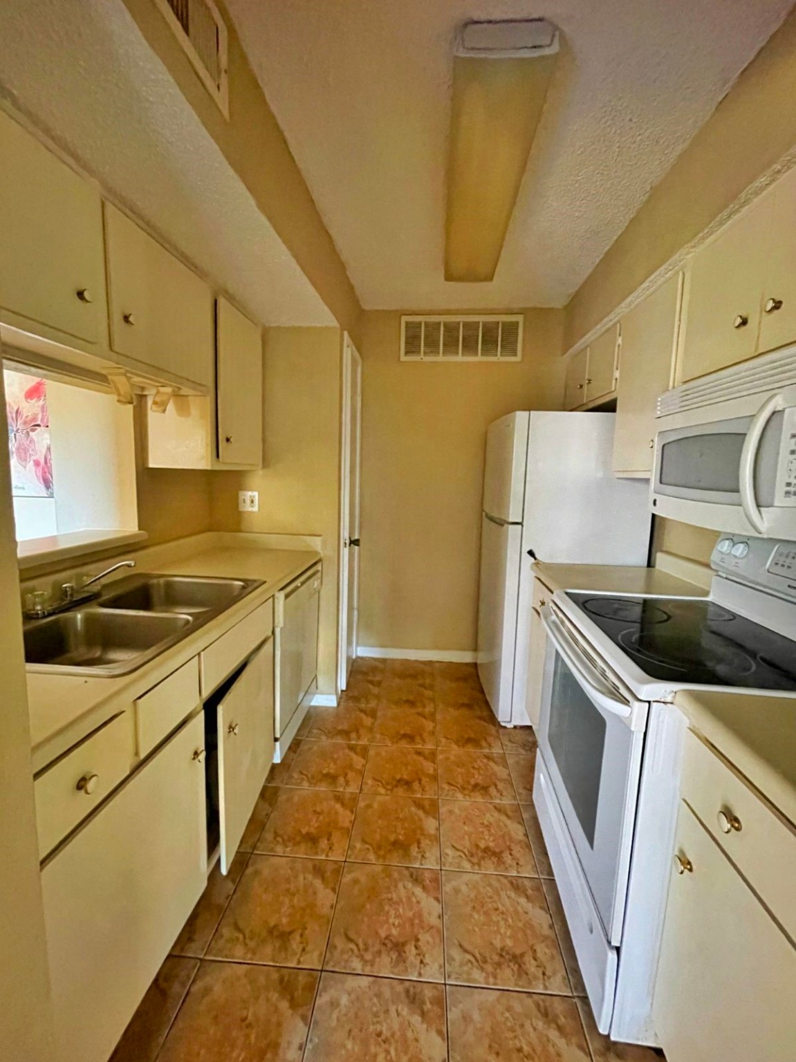 2800 Jeanetta Street, Unit 1110 Houston, TX 77063 - Photo 5 of 6 a kitchen with a sink a stove top oven and cabinets