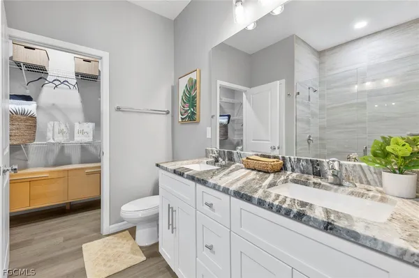a bathroom with a granite countertop sink toilet and shower