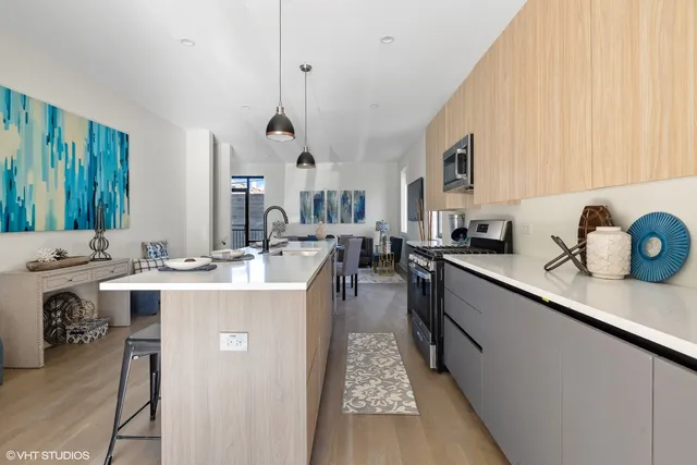 a large kitchen with kitchen island a sink stove and cabinets