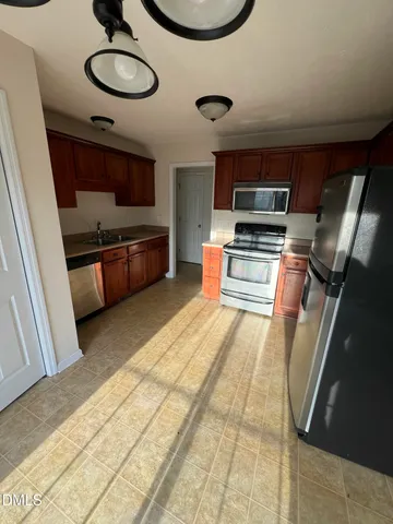 a kitchen with stainless steel appliances granite countertop a sink and a refrigerator