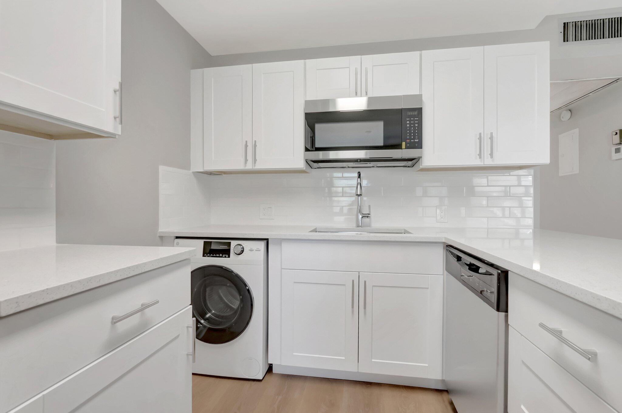 296 Fanshaw H Boca Raton, FL 33434 - Photo 1 of 59 a kitchen with white cabinets and stainless steel appliances