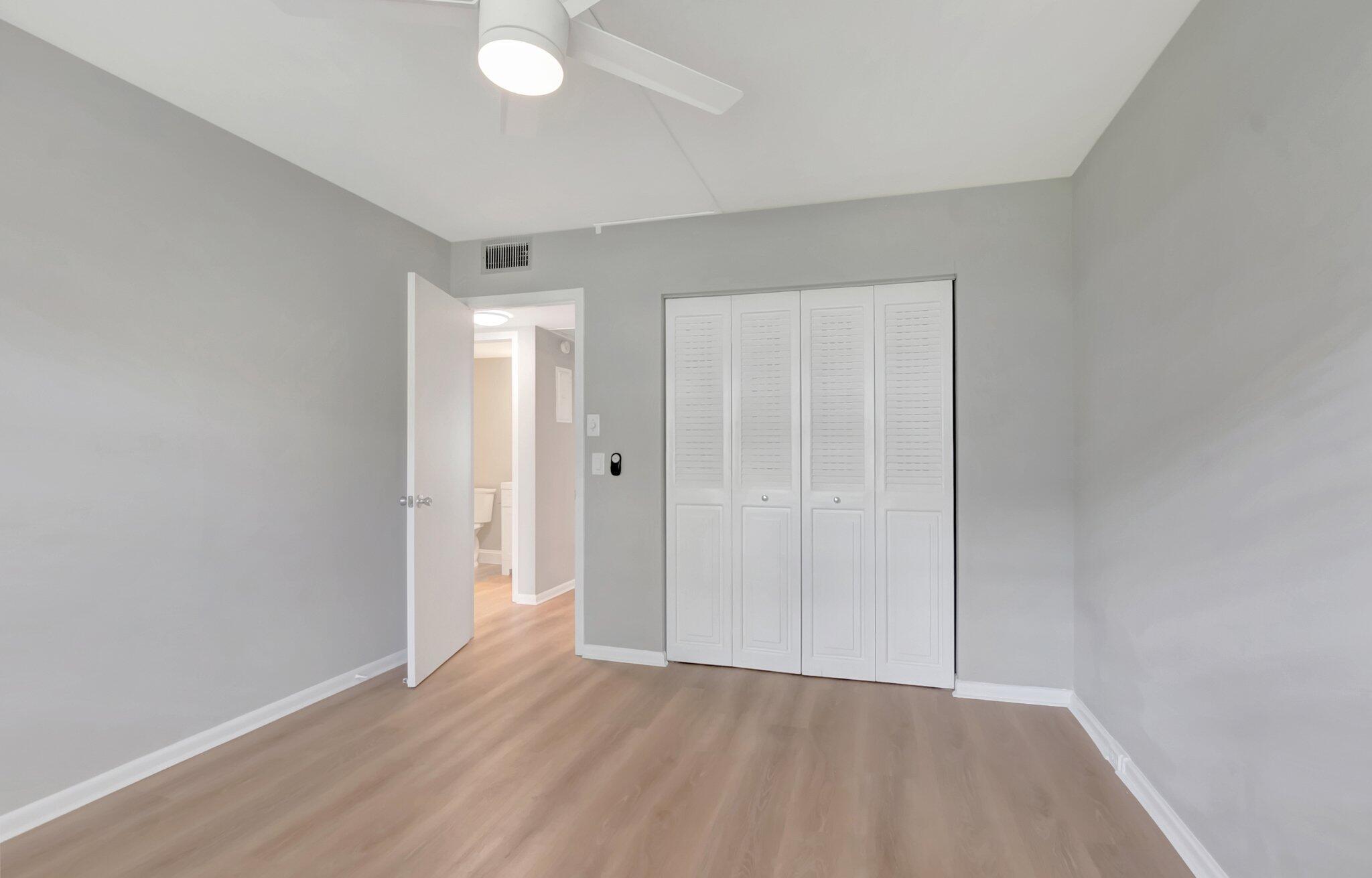 296 Fanshaw H Boca Raton, FL 33434 - Photo 13 of 59 an empty room with wooden floor and windows