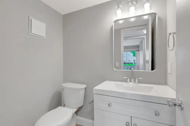 a bathroom with a toilet a sink and mirror