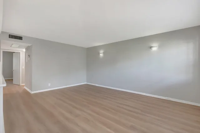 a view of an empty room with wooden floor