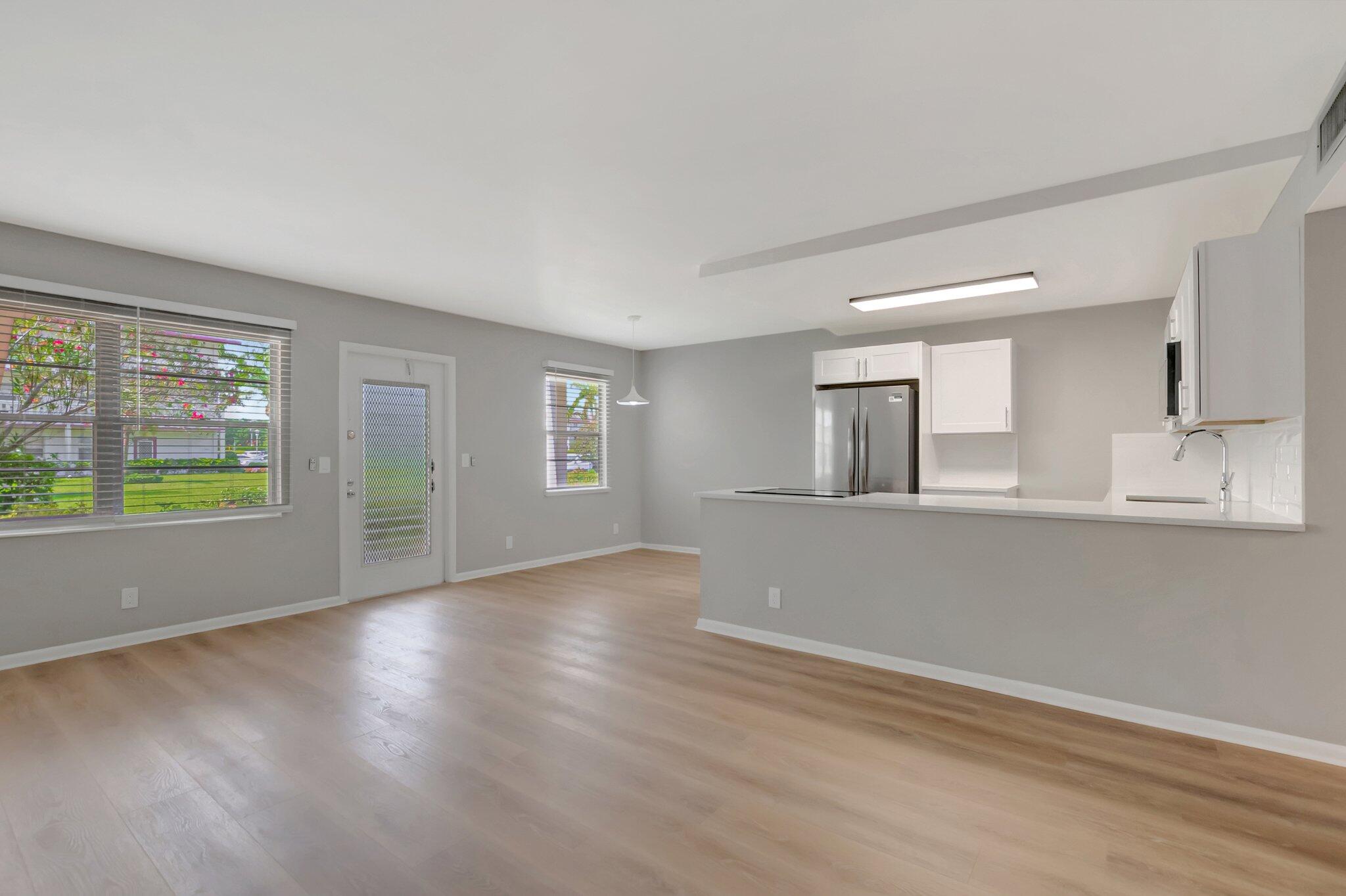 296 Fanshaw H Boca Raton, FL 33434 - Photo 9 of 59 a view of a kitchen with wooden floor and a window