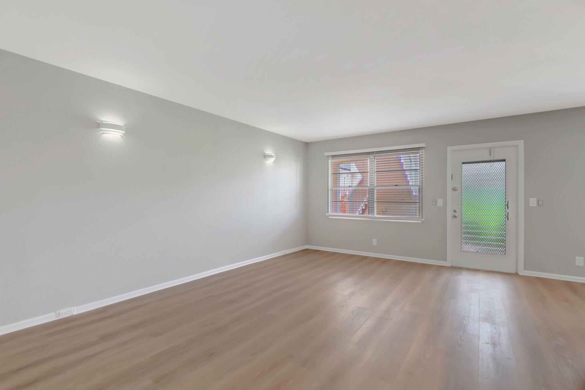 296 Fanshaw H Boca Raton, FL 33434 - Photo 10 of 59 a view of an empty room with wooden floor and a window