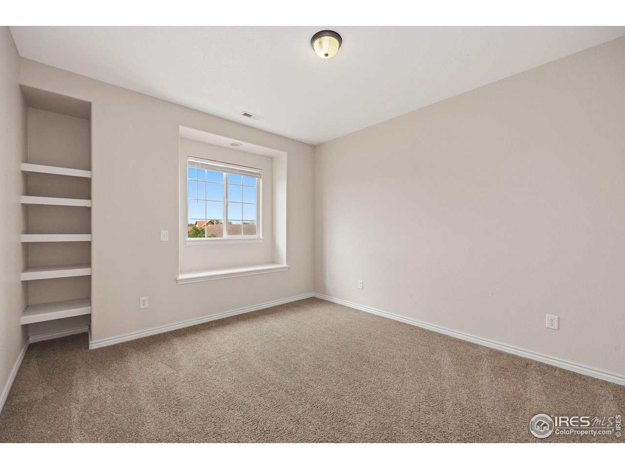 3427 Red Hawk Lane Longmont, CO 80504 - Photo 18 of 33 a view of an empty room with a window and wooden floor