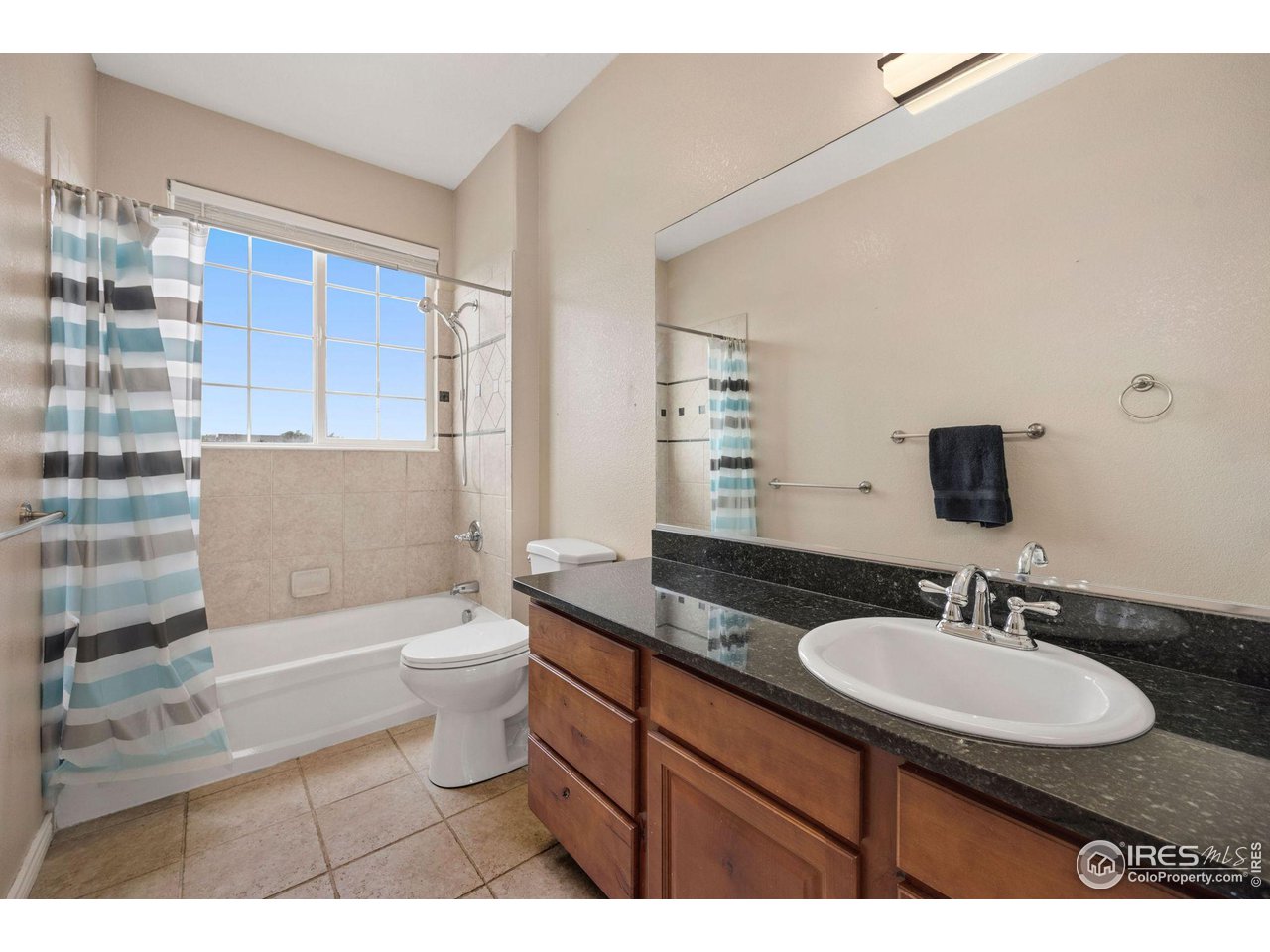 3427 Red Hawk Lane Longmont, CO 80504 - Photo 20 of 33 a bathroom with a granite countertop sink toilet a mirror and bathtub